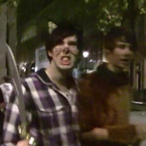 an image of dan and phil on halloween 2009. phil holds a fake knife at the camera.