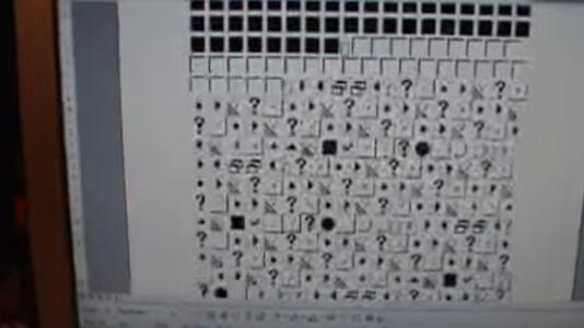 a photo of an old-school monitor that displays a document covered in the wingdings font